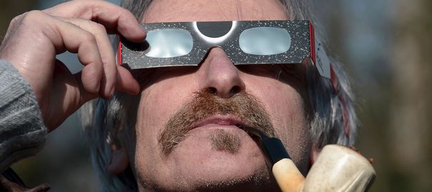 un-homme-regarde-l-eclipse-solaire-partielle-a-travers-des-lunettes-de-protection-le-20-mars-2015_5305185